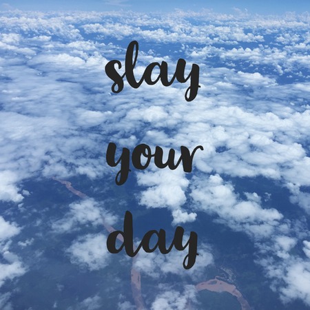 Inspirational motivational travel quote slay your day on sky background.