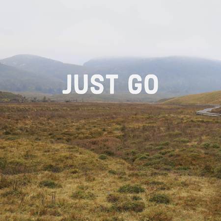 Inspirational motivational quote Just Go on mountain background.