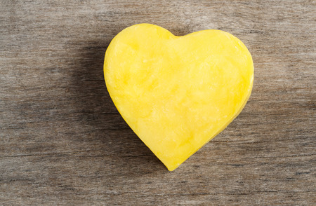 yellow heart shape on wood backgroundの写真素材