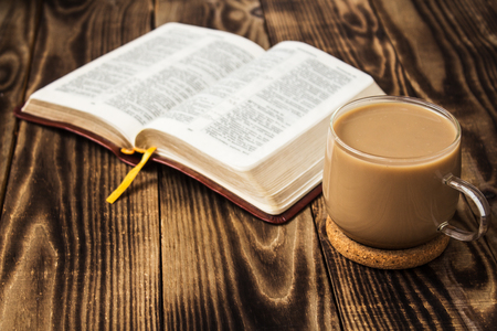 a bible and coffee with milk on wooden backgroundの写真素材