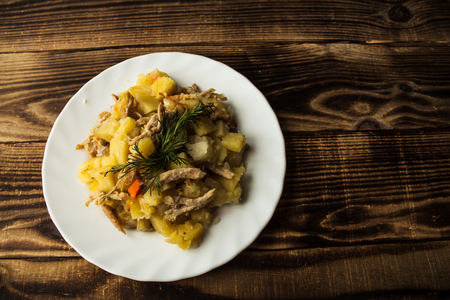 a baked potatoes with meat, carrots and onionsの写真素材