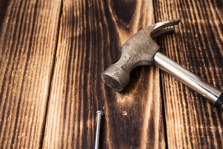 nail and a hammer on wooden backgroundの写真素材