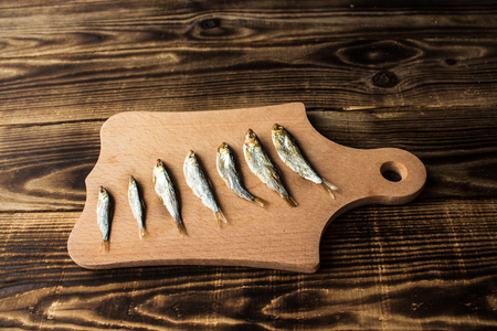 a little smoked sprats on wooden backgroundの写真素材