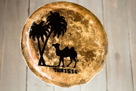 leather handmade drum with the inscription Tunisia wooden backgroundの写真素材