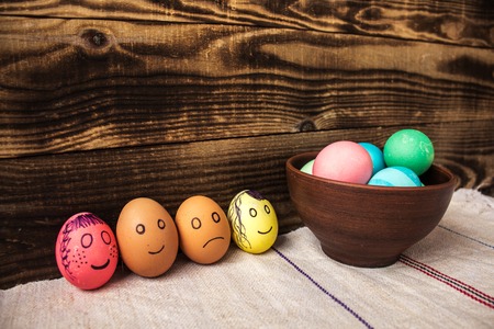 an eggs with drawn emotions on wooden backgroundの写真素材