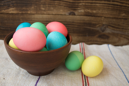 easter coroed eggs in bowl on wooden backgroundの写真素材