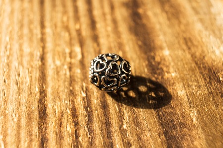 a silver bead for bracelet on wooden background
