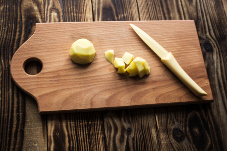 the cutted potato wooden board on wooden backgroundの写真素材