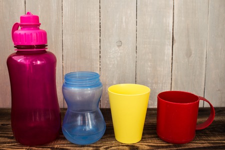 different size and colors of plastic cups on wooden backgroundの写真素材