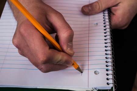 a man holding a notebook and pencil
