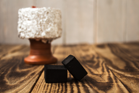 Hookah bowl with tobacco and charcoal on wooden backgroundの写真素材