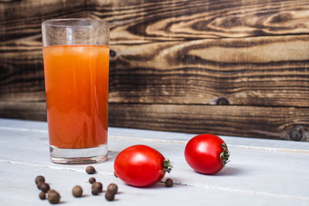 tomato juice with tomatos and pepper on wooden backgroundの写真素材