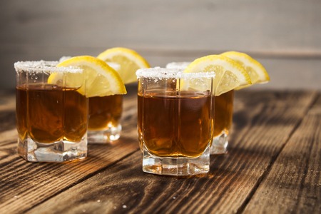 alcohol shot drinks with lemon and salt on wooden backgroundの写真素材