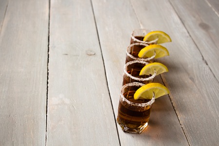 alcohol shot drinks with lemon and salt on wooden backgroundの写真素材