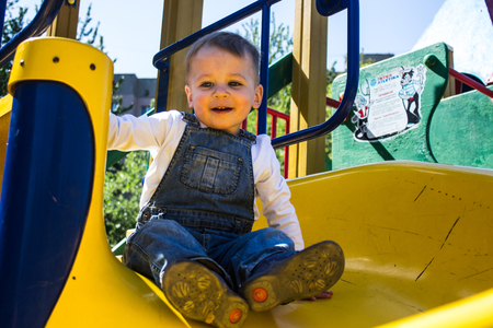 baby boy playing on the playground summer morningの写真素材