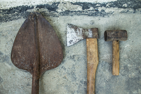 a Rusty ax hammer and shovel on a white background