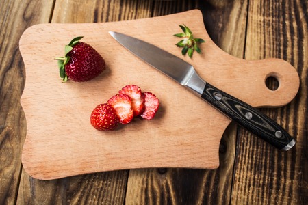 fresh strawberry on cutting board and knifeの写真素材