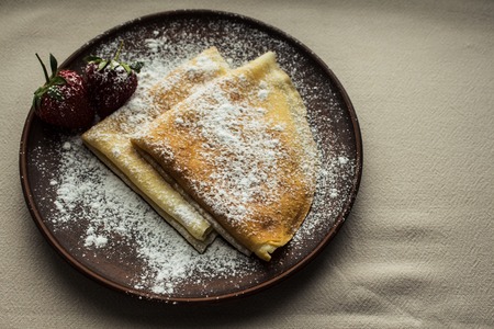 Pancakes crepe with strawberries and powdered sugarの写真素材