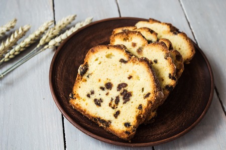 Slices of homemade cake with raisins and wheat on a light wooden backgroundの写真素材