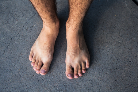 a male feet on a gray summer background