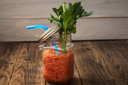 Fresh tomato smoothies and celery in a jar on wooden backgroundの写真素材