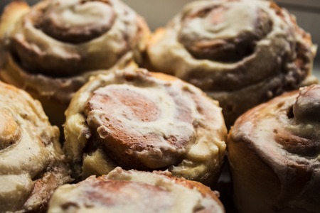 cinnamon bon rolls with frosting on plateの写真素材
