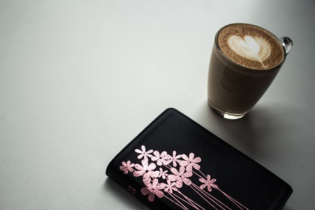 open bible and a cup of cappuccino with milk heart on white backgroundの写真素材