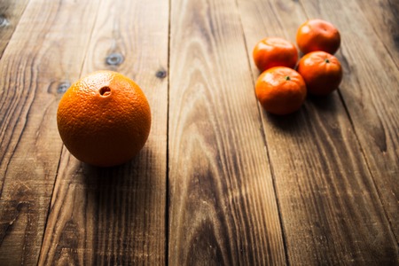 ripe mandarins and orange on a wooden bacgroundの写真素材
