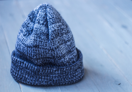 gray winter warm hat on a wooden bacgroundの写真素材