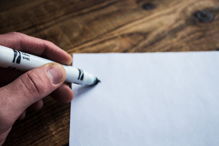 drawinga with a felt-tippers on white sheet of piper on a grey wooden bacgroundの写真素材