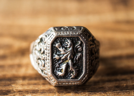 ring with a lion coat of arms on a wooden backgroundの写真素材