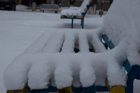 benches in the yard covered with snow in winterの写真素材