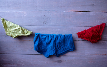 a children's clothes on a rope on a wooden backgroundの写真素材