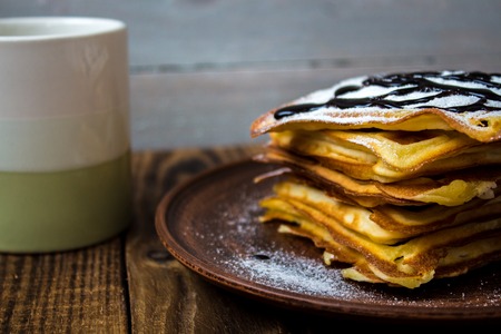 a cup of tea and a pile of wafers on wooden backgroundの写真素材