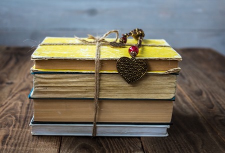 old books tied with a rope on wooden backgroundの写真素材