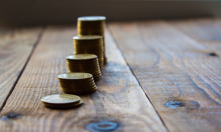 a pile of gold coins on wooden background