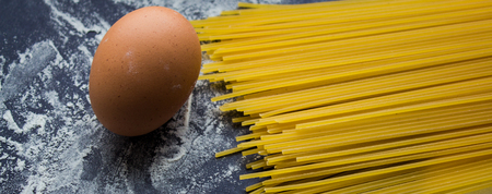 a spaghetti and flour on black backgroundの写真素材