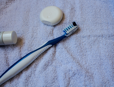 a dental floss toothbrush toothpaste on the towelの写真素材