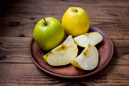 applles on the plate on wooden backgroundの写真素材