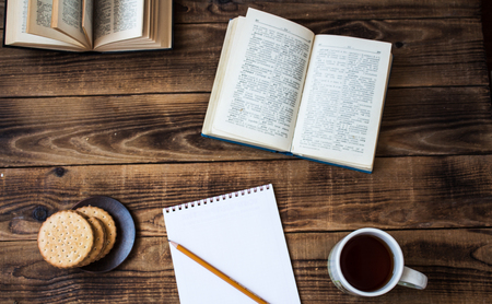 a cookies and tea open book pencil notebook on wooden backgroundの写真素材