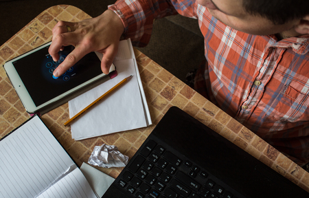 a laptop tablet and notebook with pencil on the table with a manの写真素材