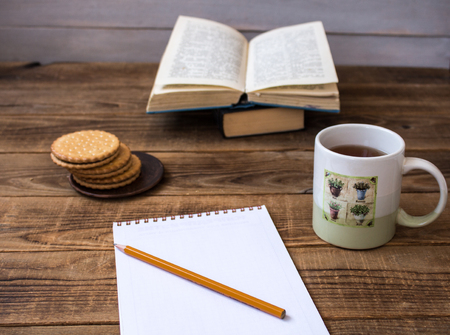 cookies and tea open boob pencil notebookon wooden backgroundの写真素材