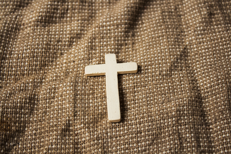 a wooden cross on a sackcloth backgroundの写真素材