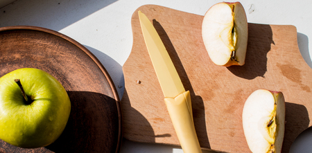 a slices apple and knife in the sunの写真素材