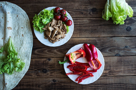 pita grilled meat tomatoes pepper on a plate and salad on wooden backgroundの写真素材