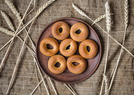 a bagels in a plate with spikelets on sackcloth backgroundの写真素材