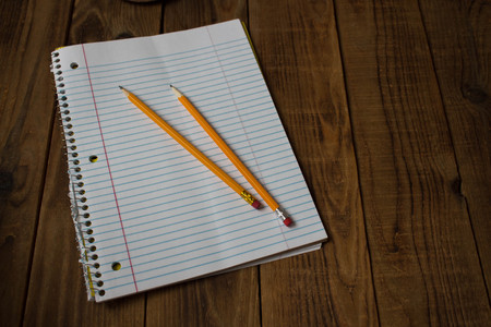 notepad with pencils on wooden backgroundの写真素材