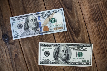 two dollar bills on a wooden background