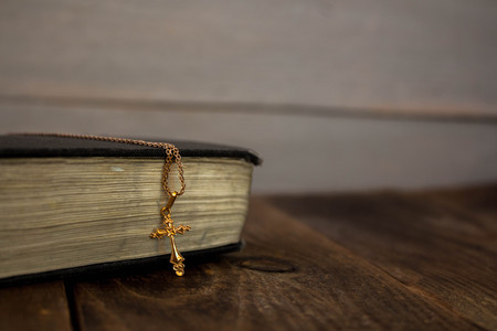 bible and golden cross on wooden backgroundの写真素材