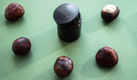jar of cream and chestnuts on a green backgroundの写真素材